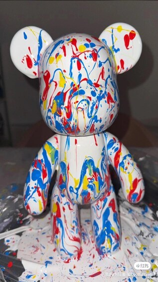 A white bear figurine with colorful paint splatters. 2