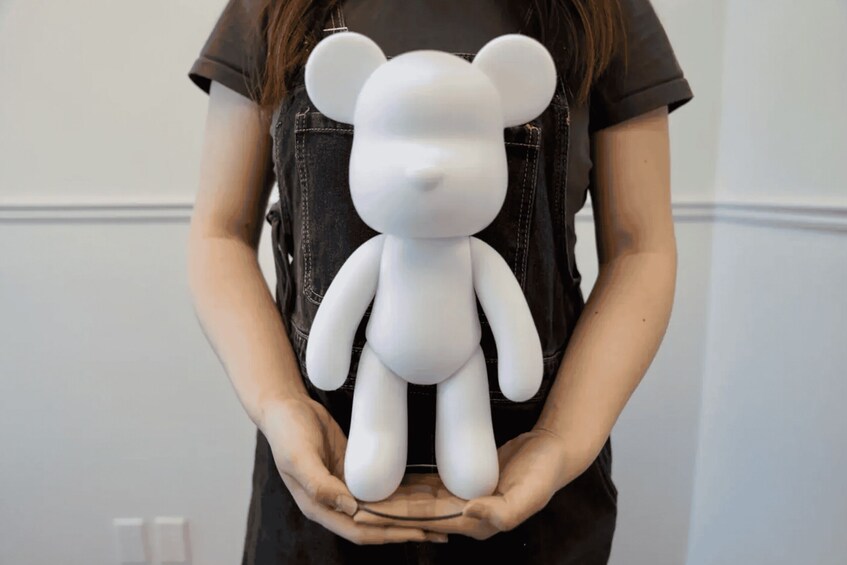 A person holding a white bear-shaped object. 3