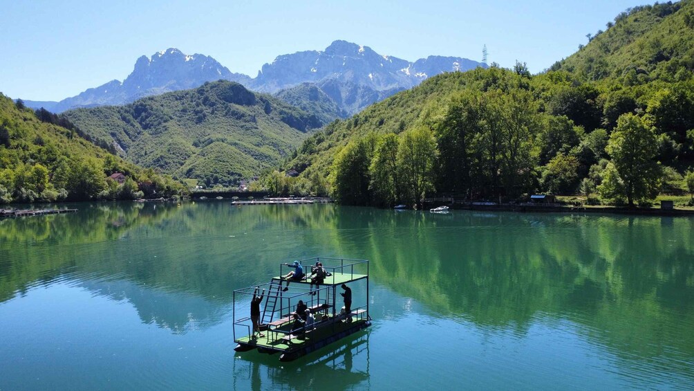 A boat on a calm lake with mountains in the background. 3