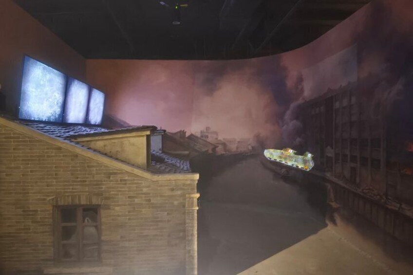 A model of a cityscape with a river, buildings, and a bridge. 3