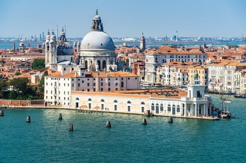 A historic Venetian cityscape with a prominent dome and waterfront buildings. 1