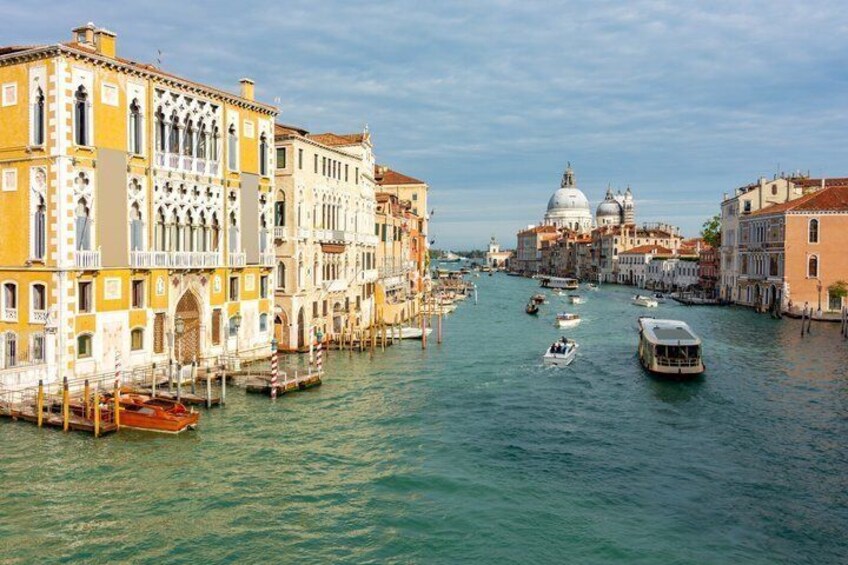 A canal with buildings, gondolas, and a large dome structure. 2