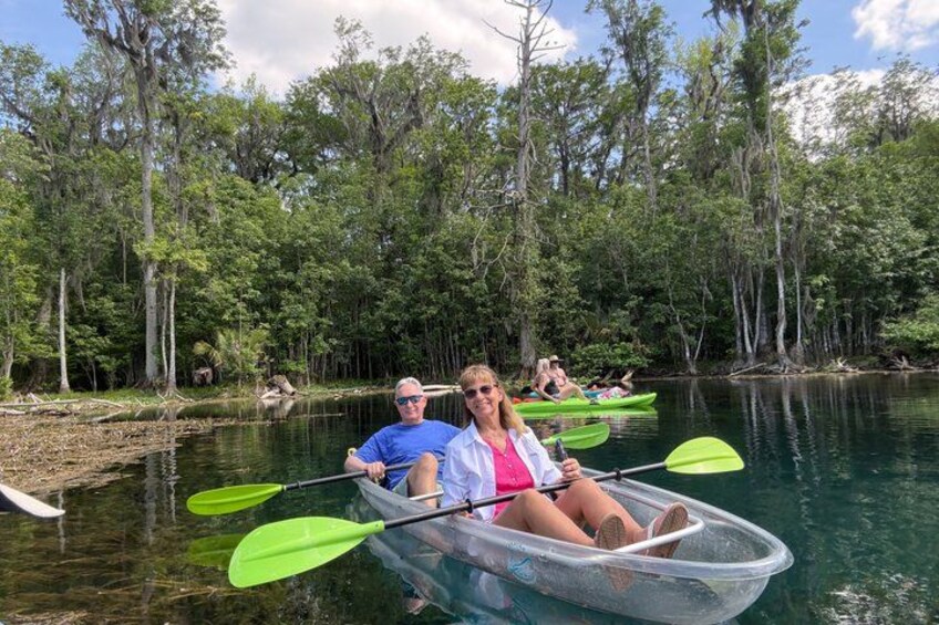 Des personnes pratiquent le kayak sur une rivière paisible, entourée d’une forêt dense. 5