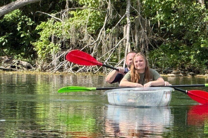 Two people in a small boat on a calm river surrounded by dense foliage. 4