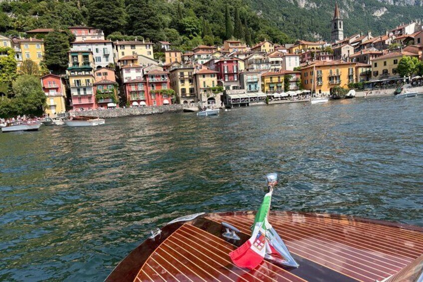 A boat on a lake with colorful buildings in the background. 2