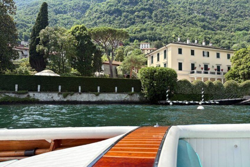 A boat on water with a building and trees in the background. 5