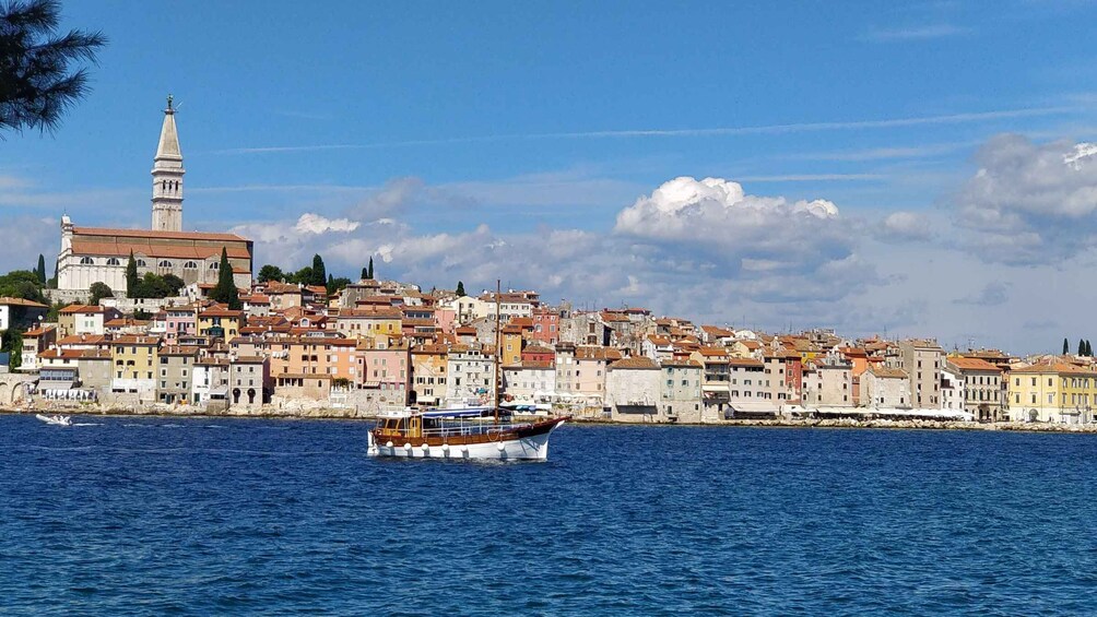 A coastal town with historic buildings, a prominent church, and a boat on the water. 2