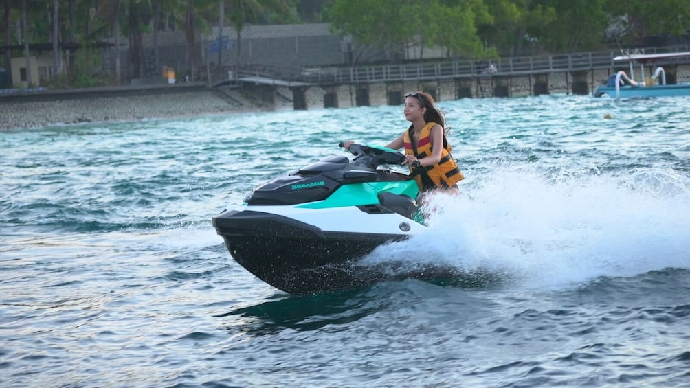 A person riding a jet ski on a body of water. 3