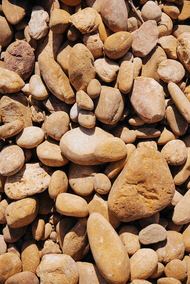 A collection of smooth, rounded pebbles of various sizes and shapes. 2