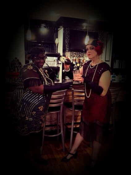 Two people at a bar with bottles and glasses. 3