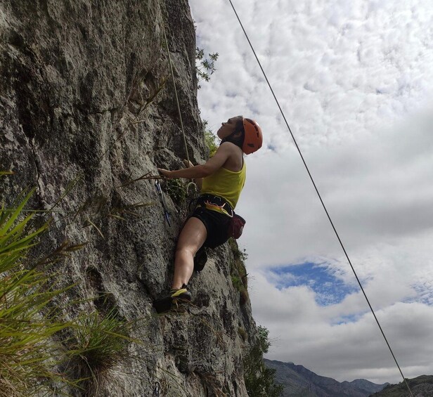 A person rock climbing a steep, rocky cliff. 5