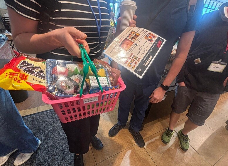 A person holding a pink basket with sushi and a menu. 4