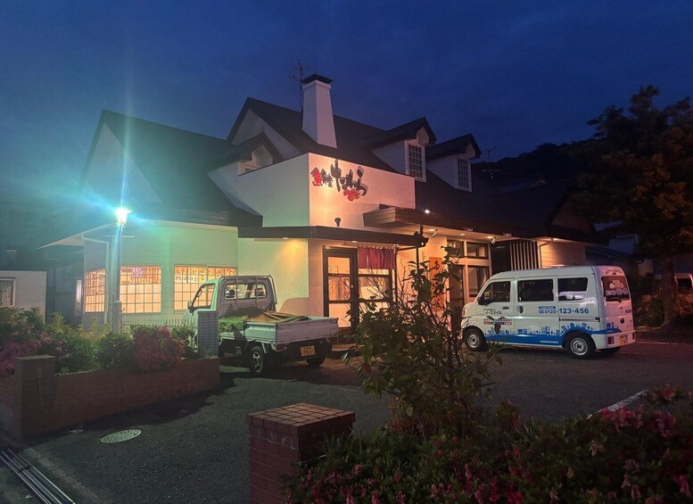 A building with a sign, a truck, and a van parked in front. 2