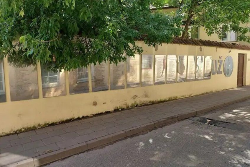 A wall with glass panels and a tree. 1