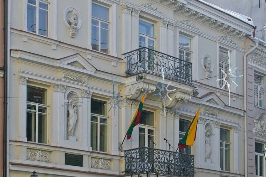 A historic building with ornate balconies and flags. 5