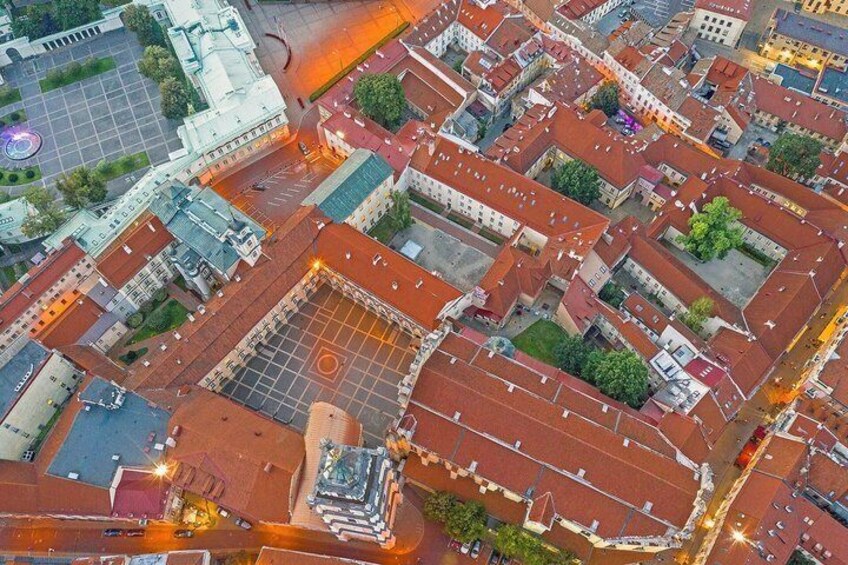 An aerial view of a city with historic buildings, a central square, and a large open space. 2