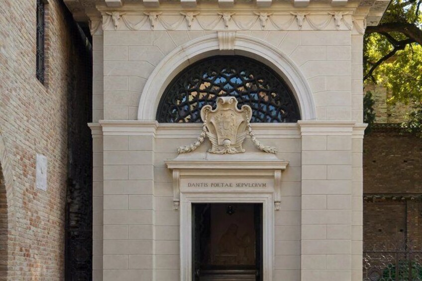 A building facade with a stone archway, a coat of arms, and the inscription 'DANTIS POETAE SEVLCRVM.' 5