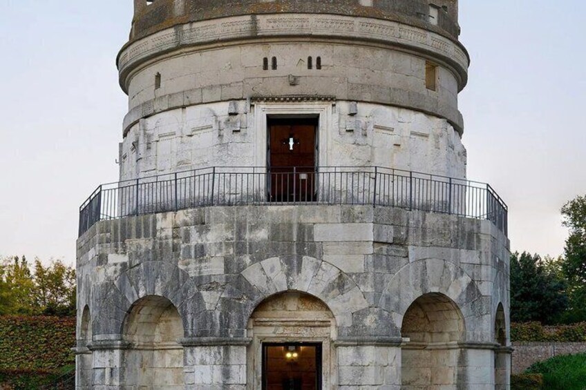 A historic tower with a balcony and arched entrance. 1