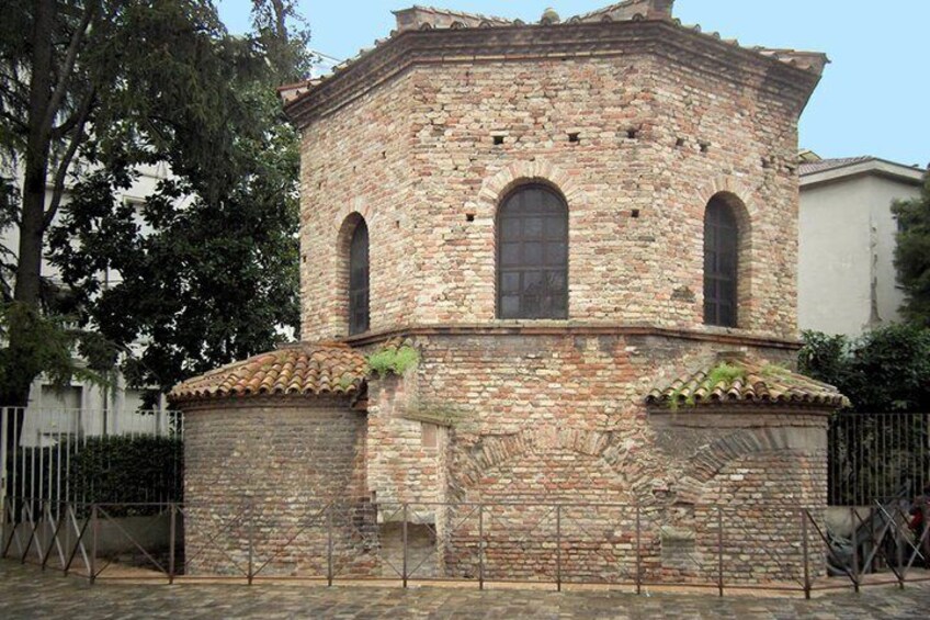 A historic stone building with arched windows and a tiled roof. 3
