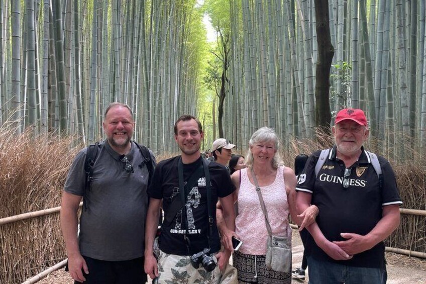 A group of people standing in a bamboo forest. 5