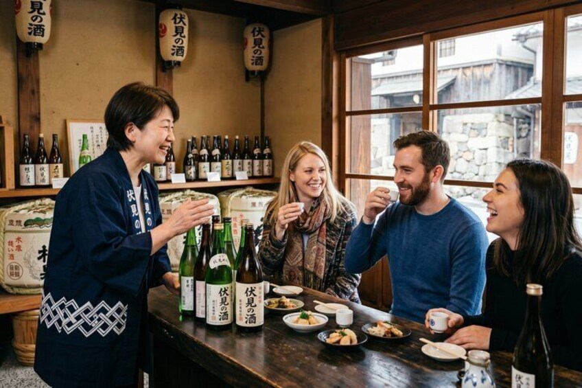 A group of people at a bar with bottles and glasses. 1