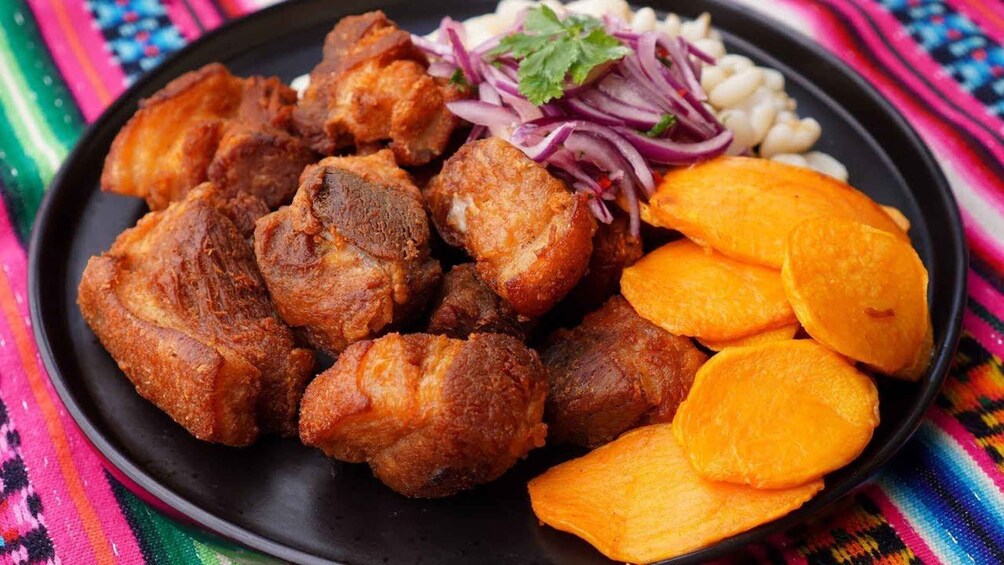 A plate of fried meat, sliced sweet potatoes, and red onion salad. 4