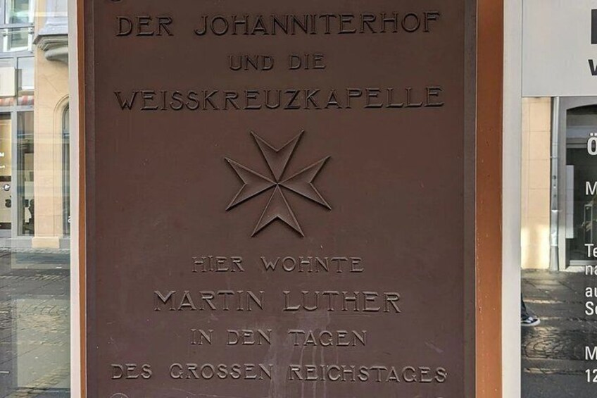 A plaque with text in German, featuring a star emblem. 5
