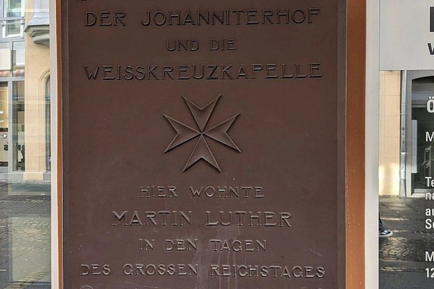 A plaque with text in German, featuring a star emblem. 5
