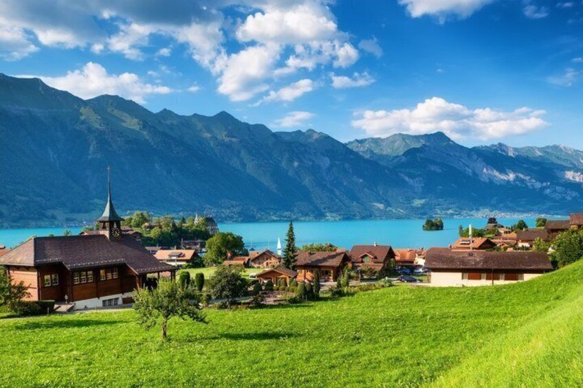 A village with traditional houses, a church, and mountains in the background. 2