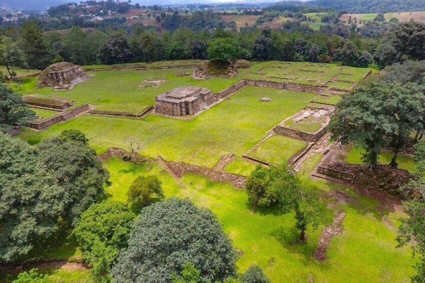 An ancient archaeological site with ruins and green fields. 2