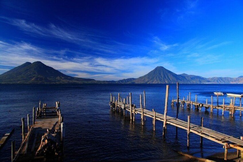 A calm lake with wooden docks and a mountain in the background. 1