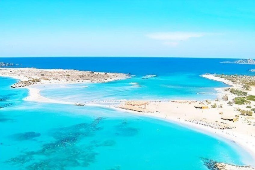 A coastal landscape with clear turquoise waters, sandy beaches, and rocky outcrops. 1