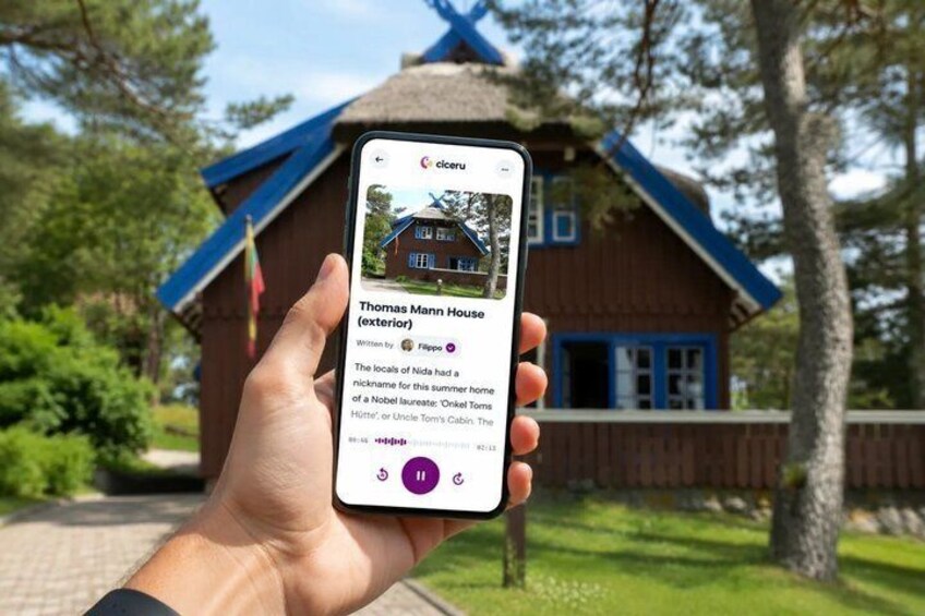 A hand holding a smartphone displaying a house named Thomas Mann House with a blue roof and a flag. 1