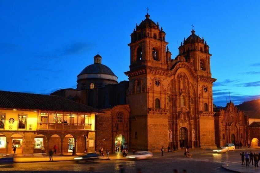 A historic cathedral with two bell towers and a dome, surrounded by a plaza with people and cars. 4
