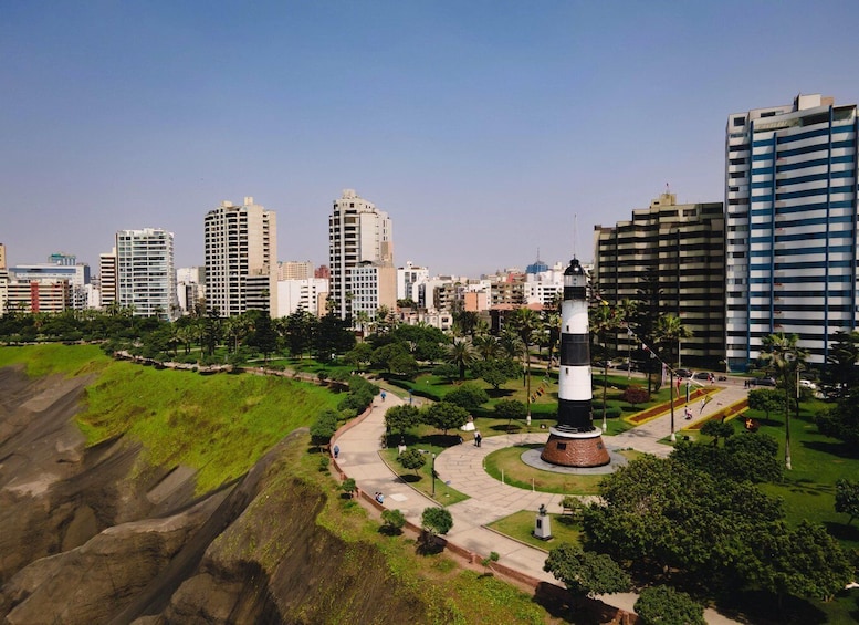 A cityscape with a lighthouse in a park, surrounded by high-rise buildings. 3