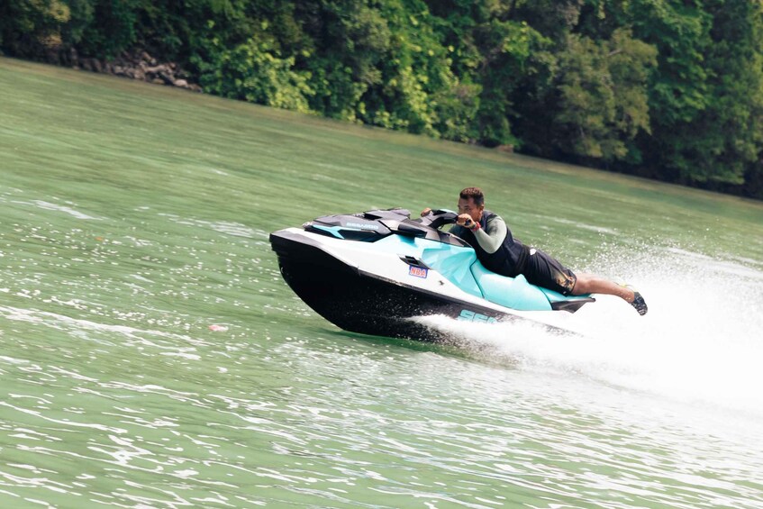 A person riding a jet ski on a body of water with trees in the background. 4