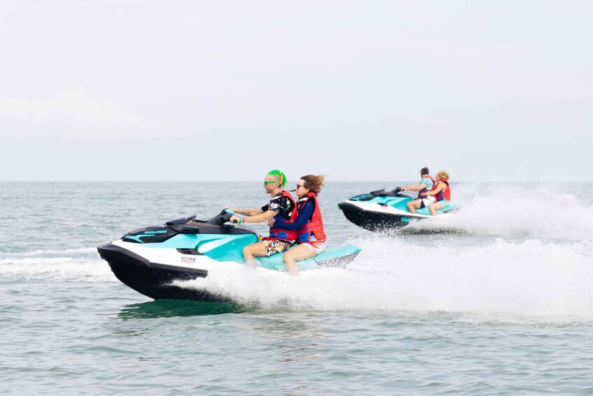 Three people jet-skiing on a calm body of water. 5