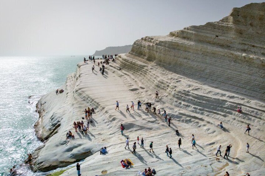 A coastal cliff with people walking and standing on it. 2