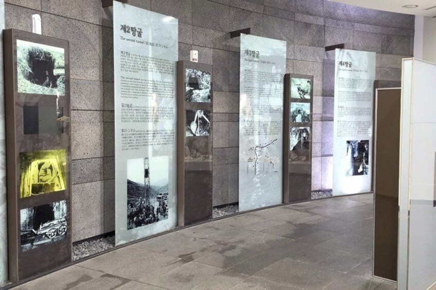 A hallway with informational panels and photographs. 3
