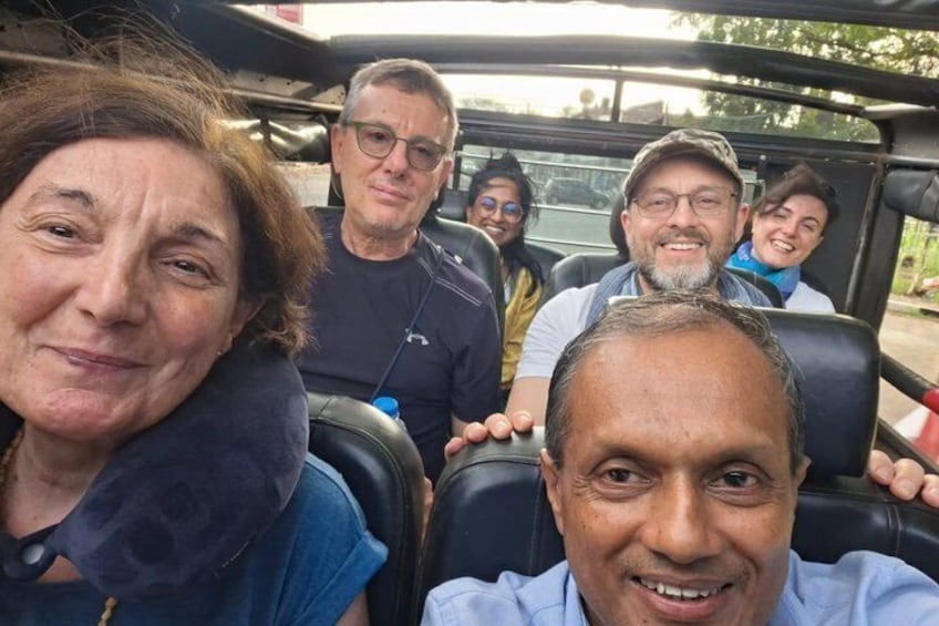 A group of people in a convertible car. 2