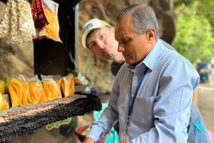 Two men at a roadside stall selling snacks. 4