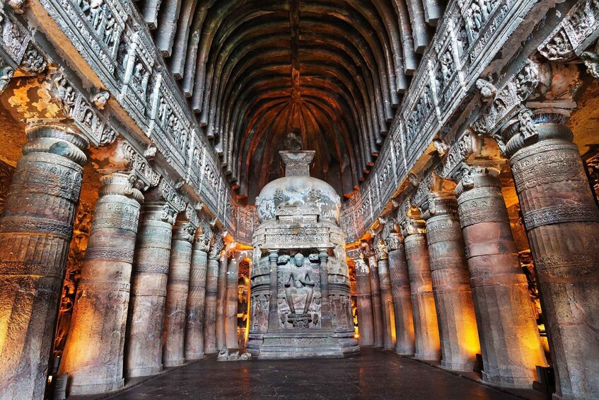 An ancient temple interior with ornate carvings and a central statue. 1