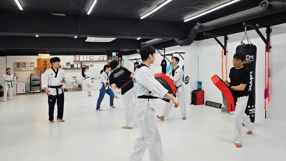 A martial arts training session with participants in white uniforms and black belts. 5