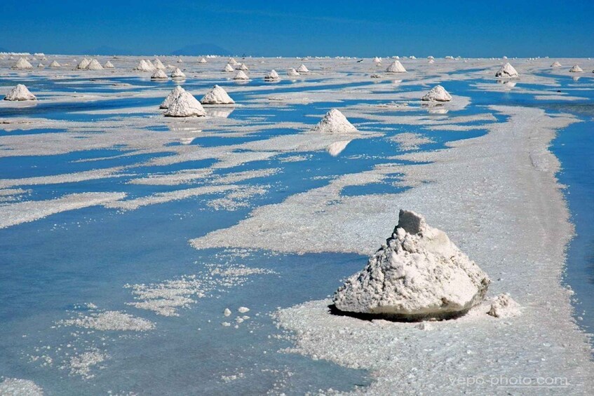 A salt flat with numerous white salt formations. 1