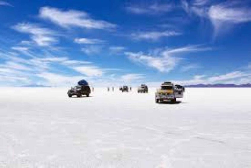 A convoy of vehicles on a snowy landscape under a clear sky. 2