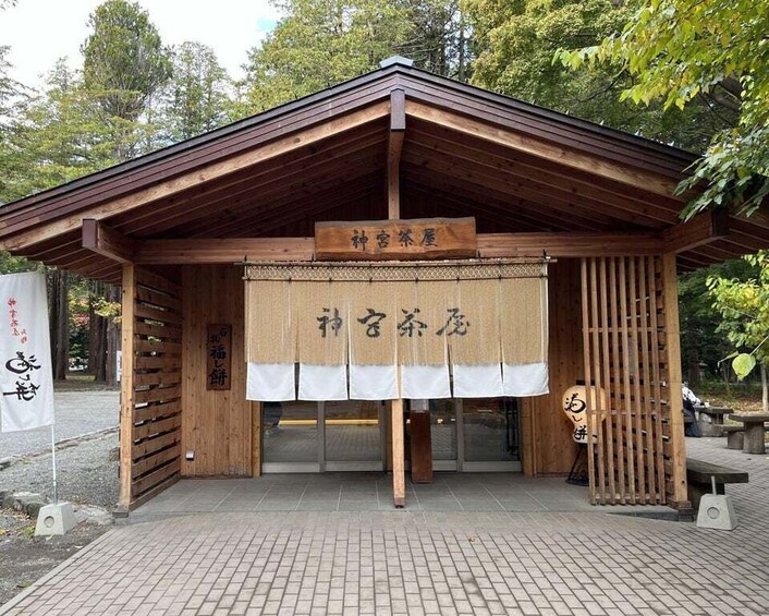 A traditional Japanese tea house with a wooden structure and a signboard. 2