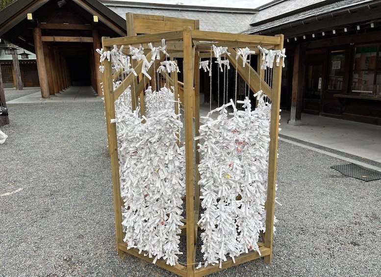 A wooden structure with white paper figures attached to it. 4