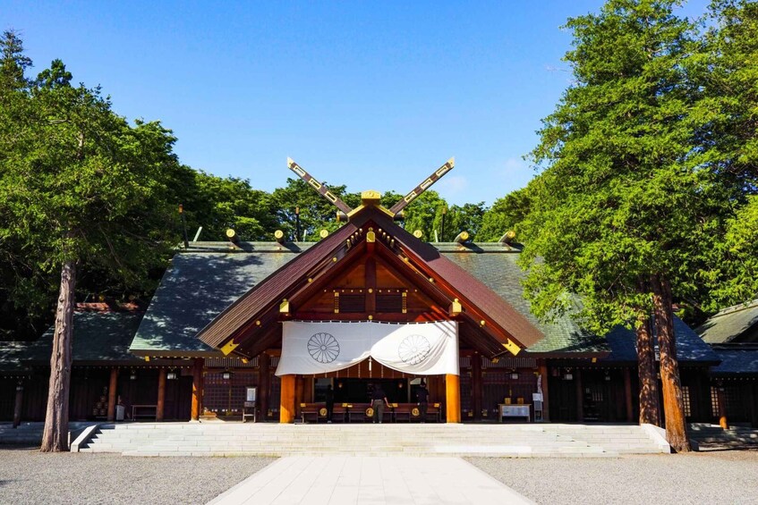 A traditional Japanese building with a thatched roof, wooden beams, and a central open space. 1