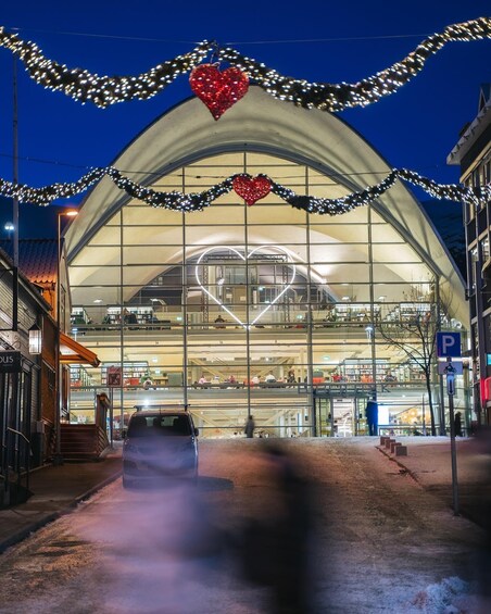 A modern building with a glass facade, decorated with heart-shaped lights and garlands. 4