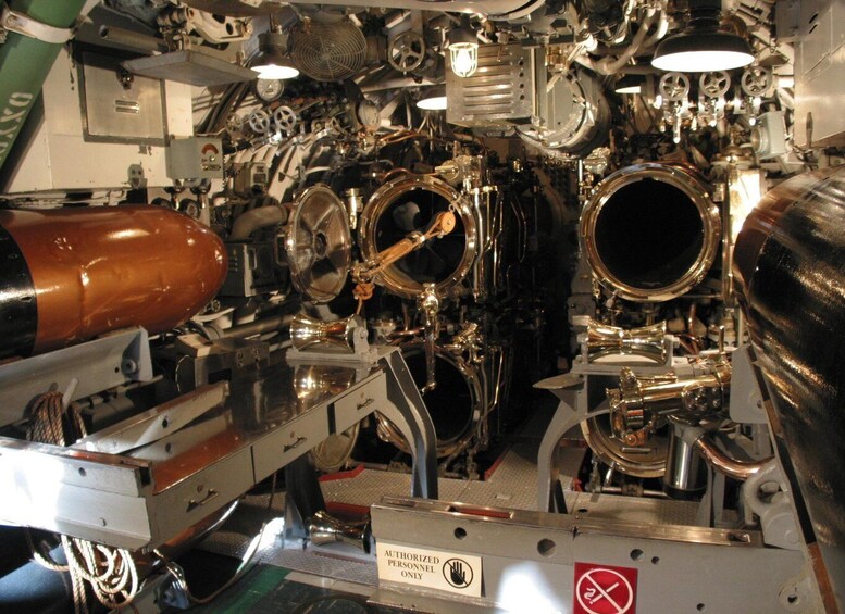 A complex mechanical structure with various metallic components and pipes, including a large cylindrical object on the left. 3